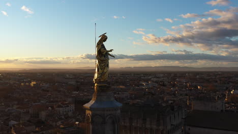 Golden-virgin-mary-statue-aerial-shot-Avignon-Palais-des-Papes-France-sunrise